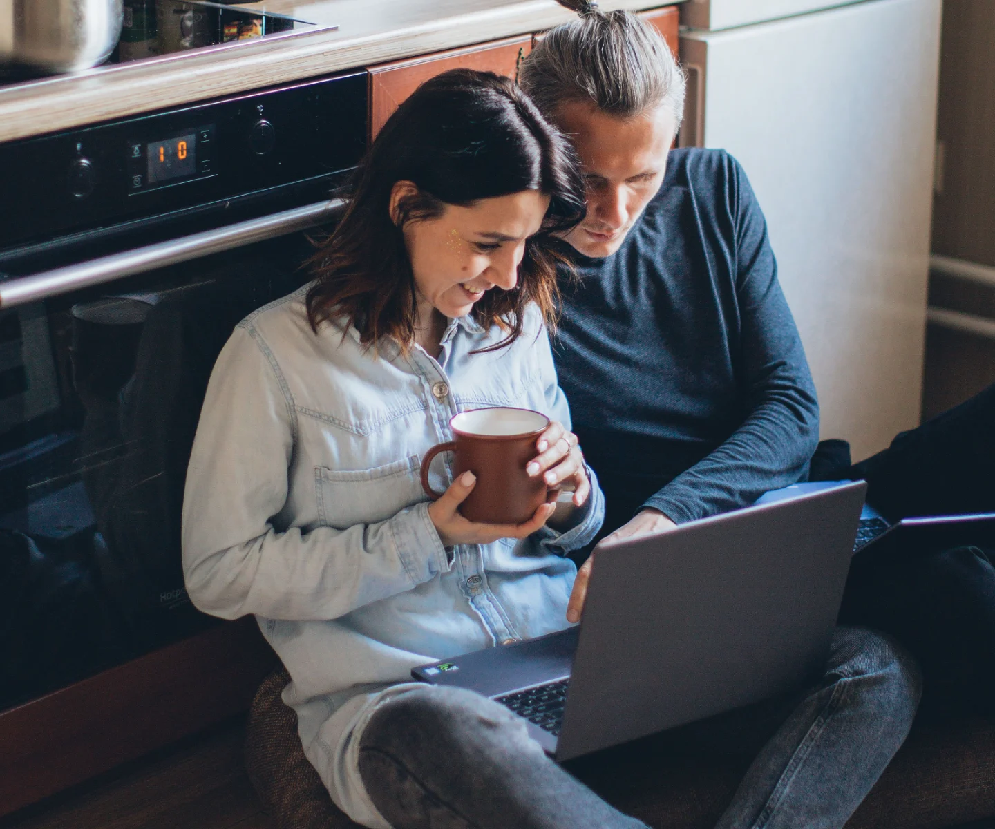 Expat couple at home getting an insurance quote on a laptop